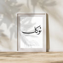 Framed Islamic wall art displayed on a light hallway wall